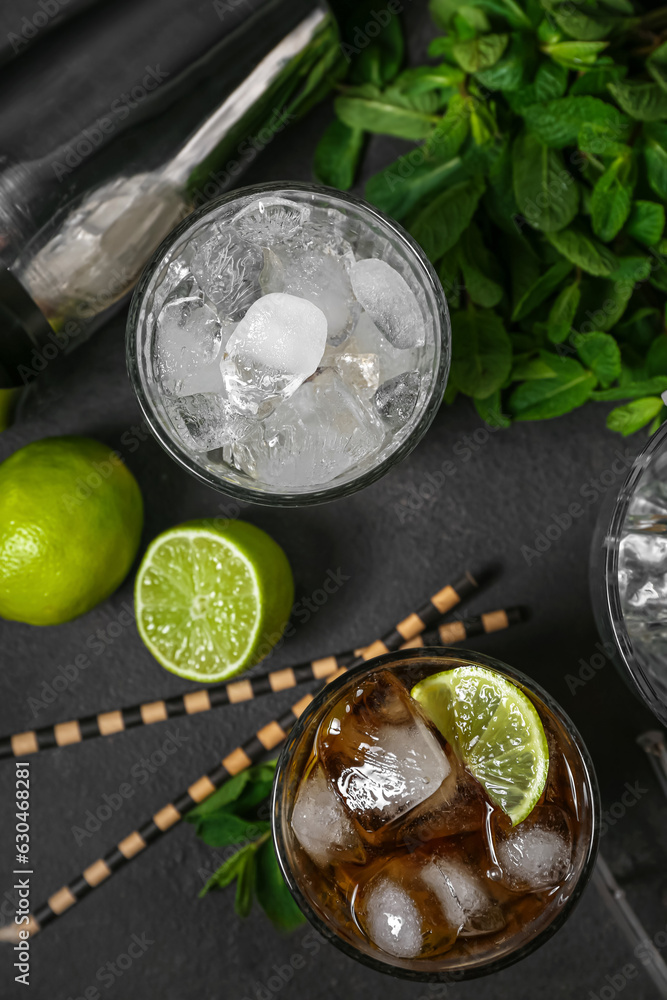 Glass of cold Cuba Libre cocktail with ice on dark background