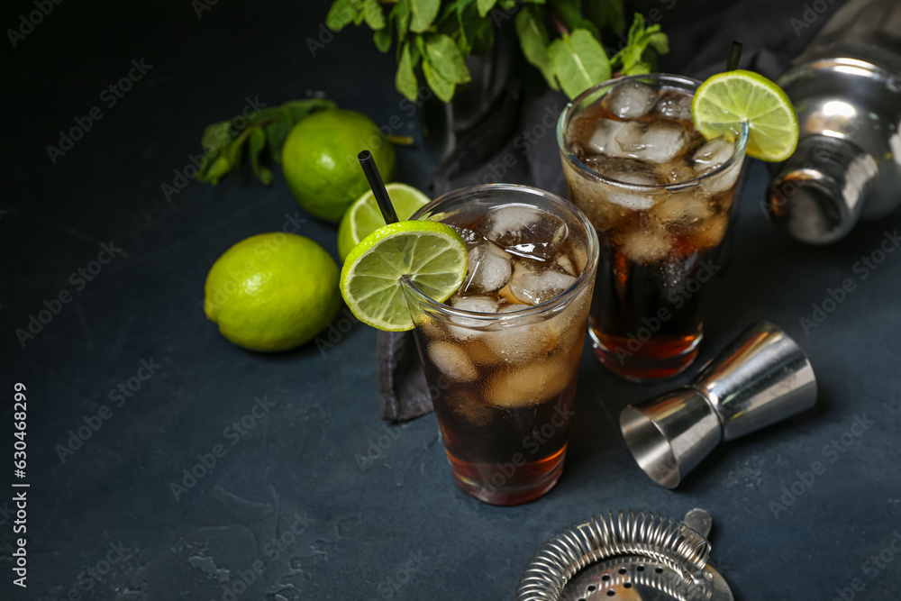 Glasses of cold Cuba Libre cocktail on dark background