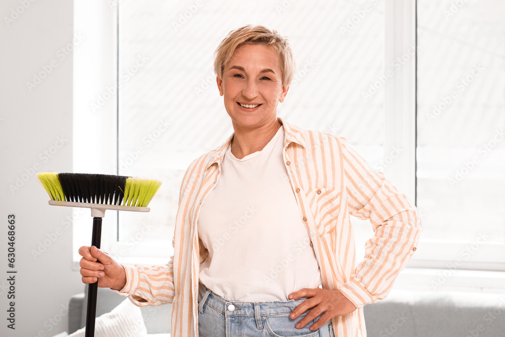 Mature woman with floor brush in room