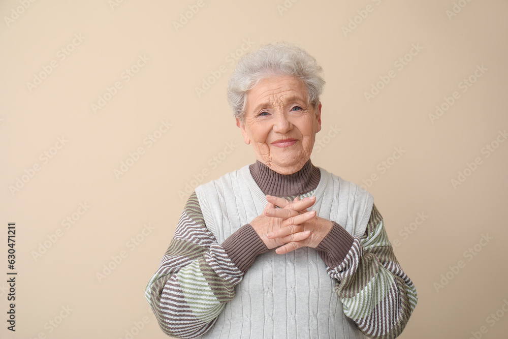 Senior woman on beige background