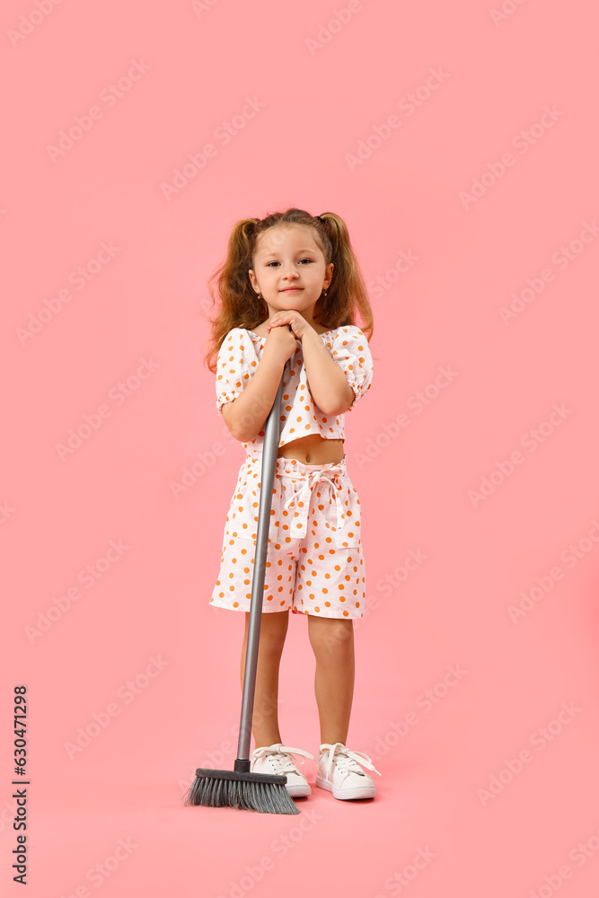 Cute little girl with broom on pink background