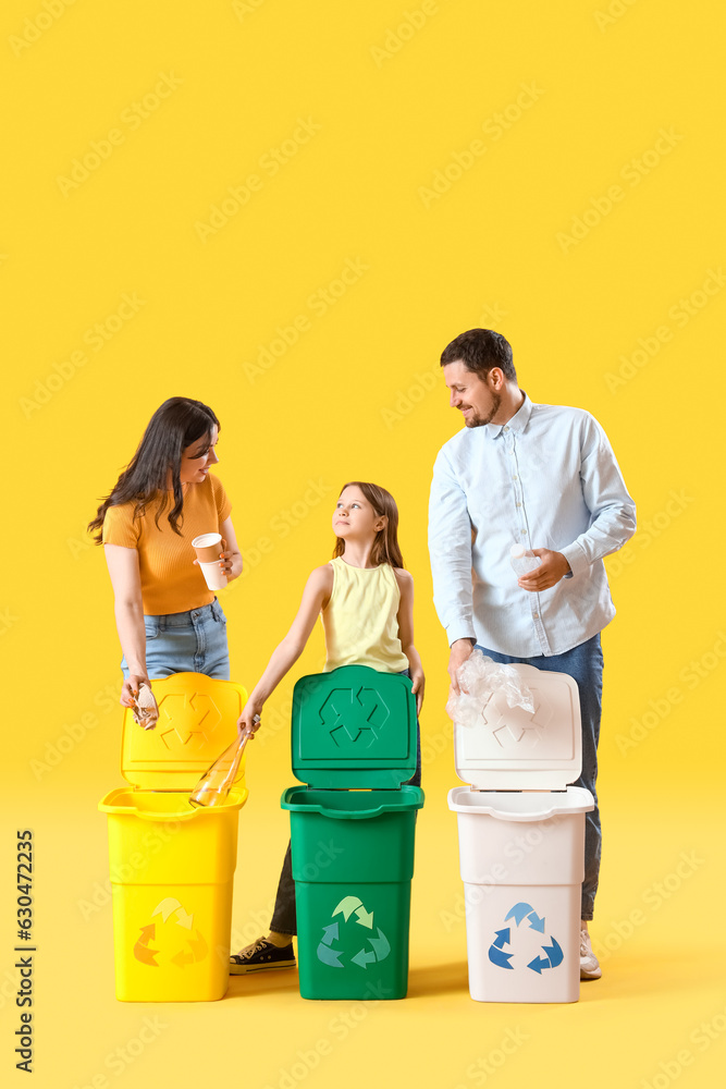 Family sorting garbage in recycle bins on yellow background