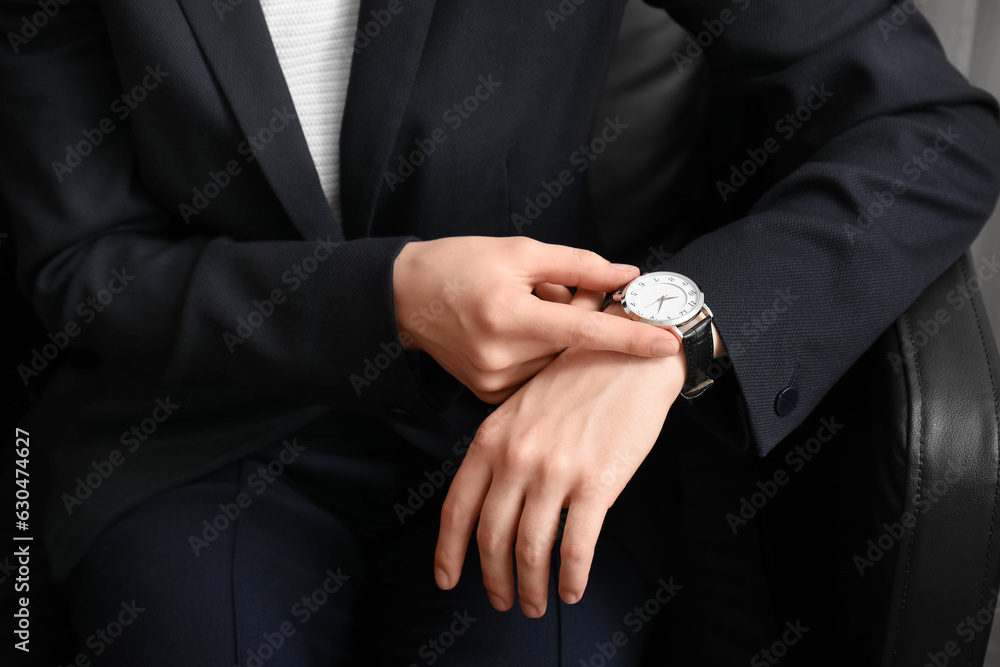 Young woman looking at wristwatch, closeup