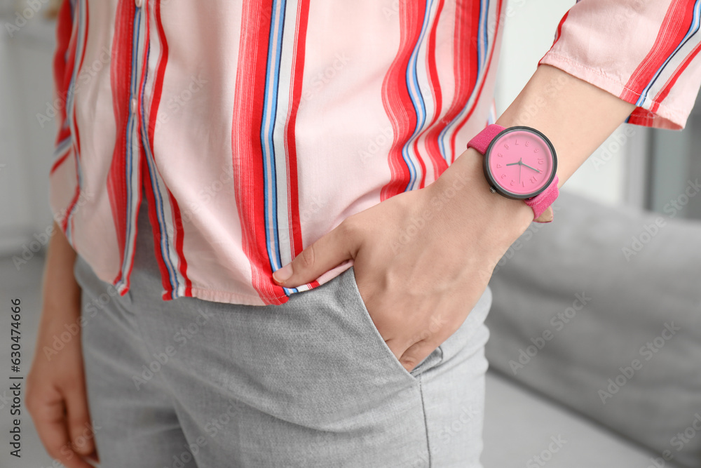 Young woman with stylish wristwatch in room, closeup