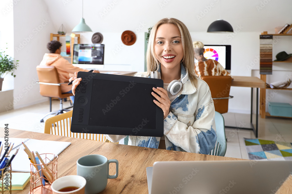 Female graphic designer working with tablet at table in office