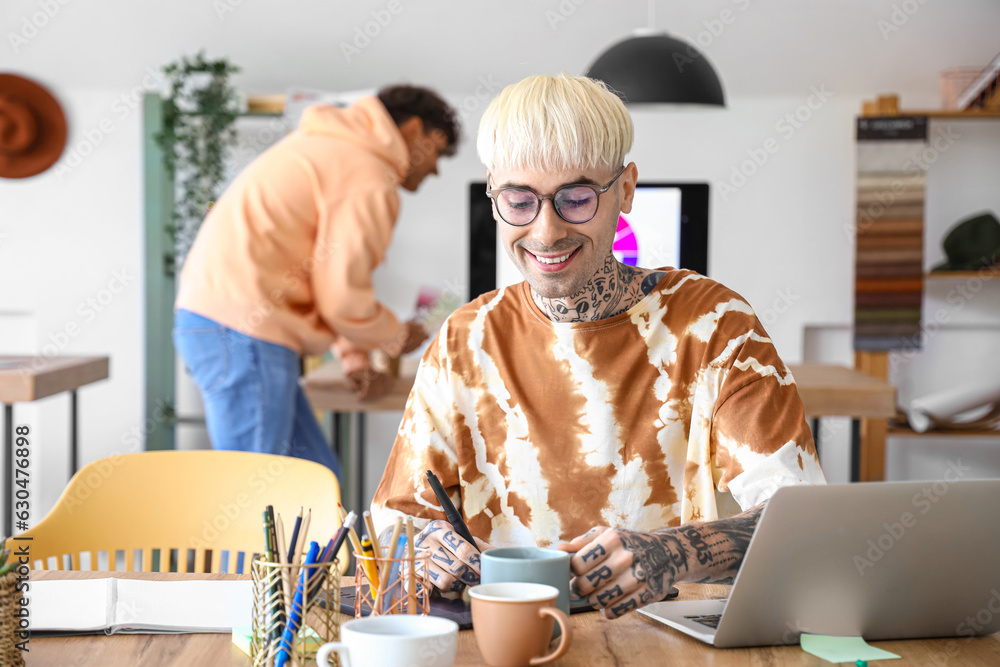 Male graphic designer working with tablet at table in office