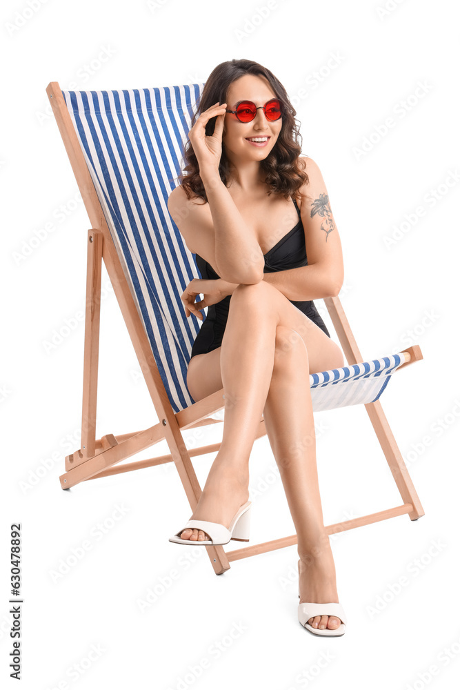 Young woman in deck chair on white background