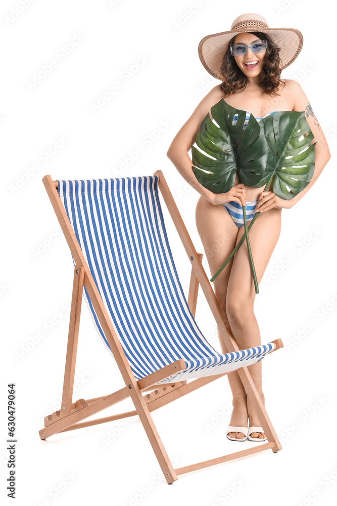 Young woman with palm leaves and deck chair on white background