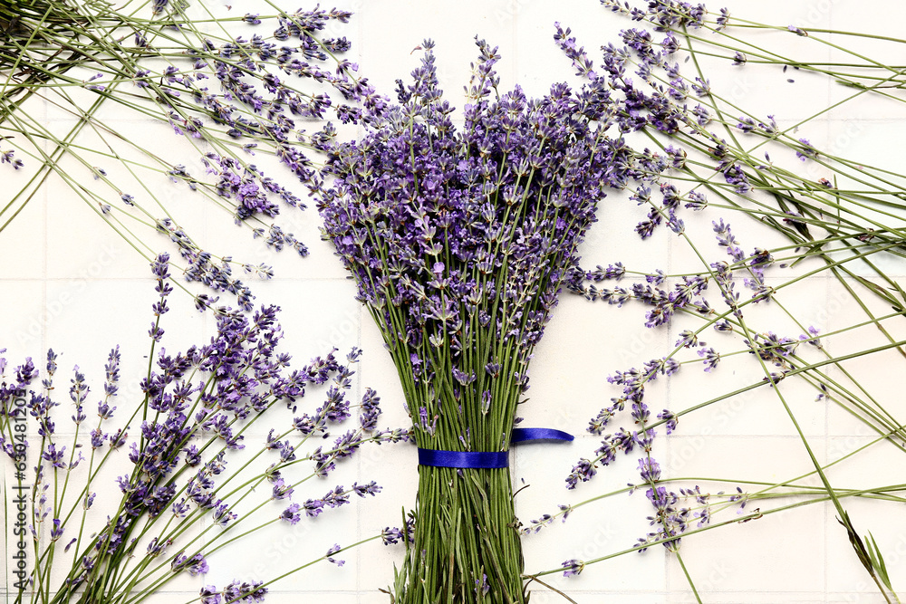 Bouquet of beautiful lavender flowers on light tile background