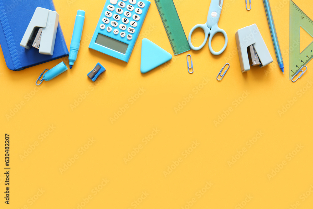 Different school stationery and notebook on orange background