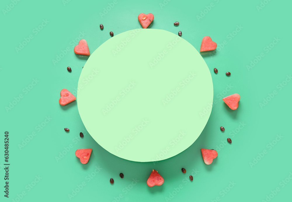 Blank card and pieces of fresh watermelon with seeds on green background