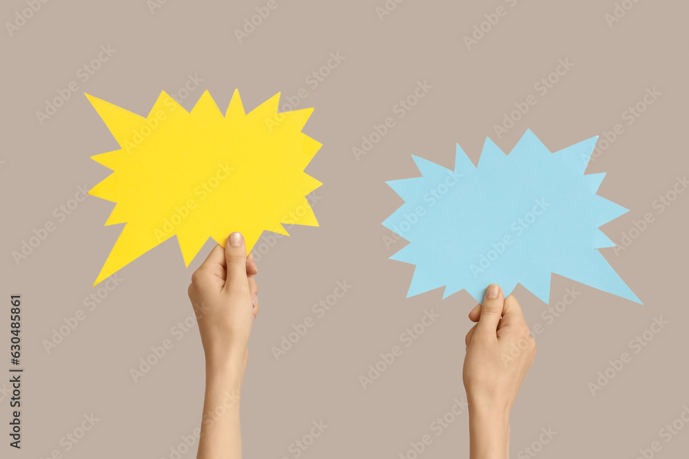 Female hands with speech bubbles on grey background