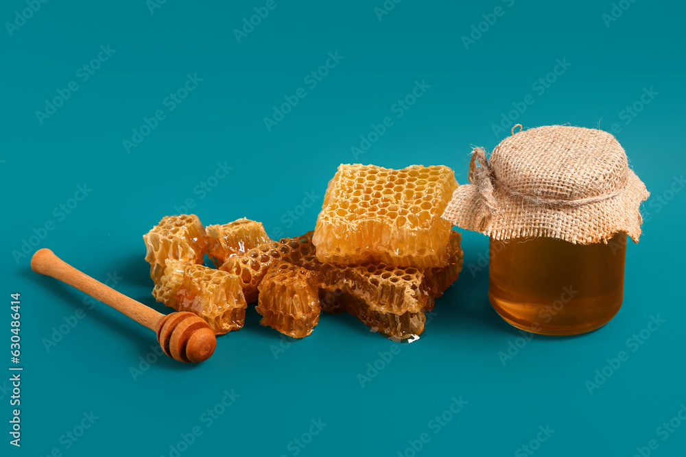 Jar with sweet honey and combs on blue background