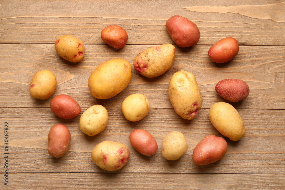 Fresh raw potatoes on wooden background