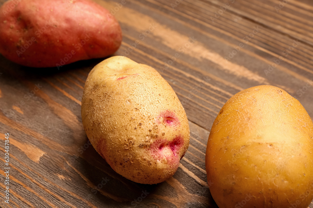 Fresh raw potatoes on wooden background