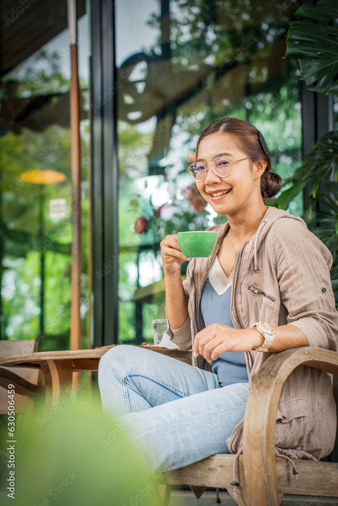 woman holding cup of cappuccino coffee in Coffee Shop.