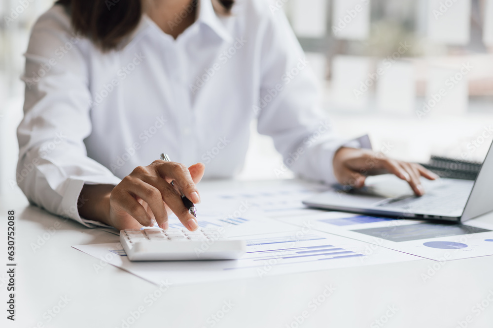 Businesswoman working with laptop and analyzing financial and accounting documents. Business woman w