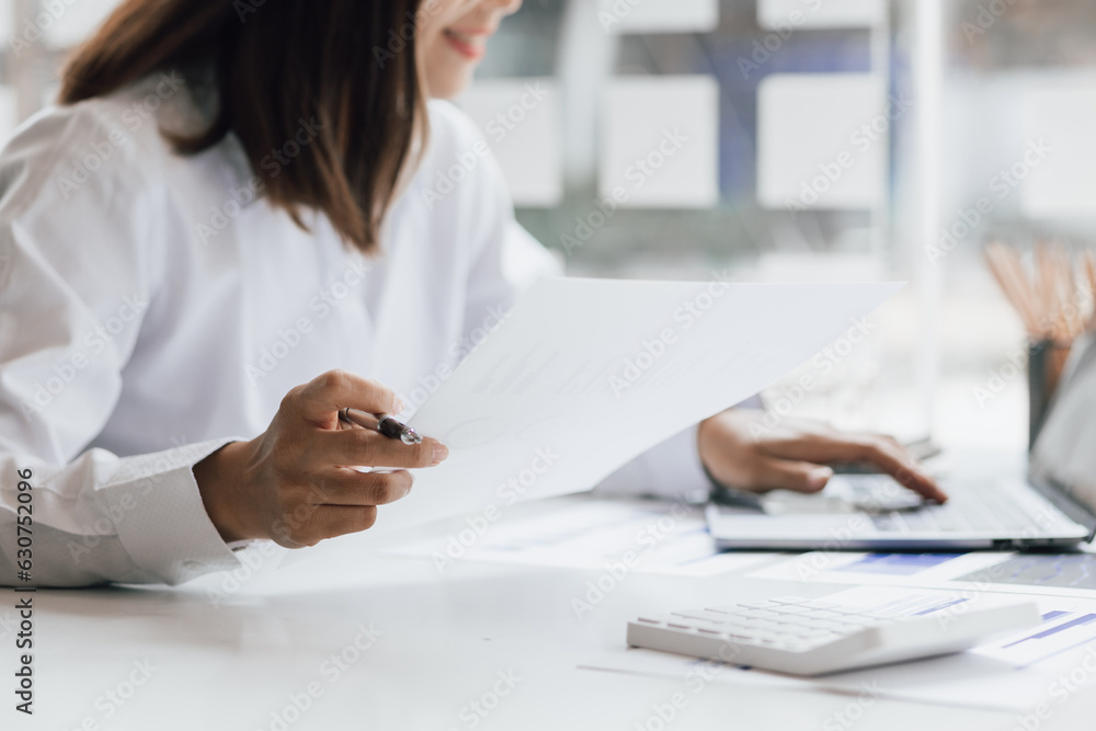 Businesswoman working with laptop and analyzing financial and accounting documents. Business woman w