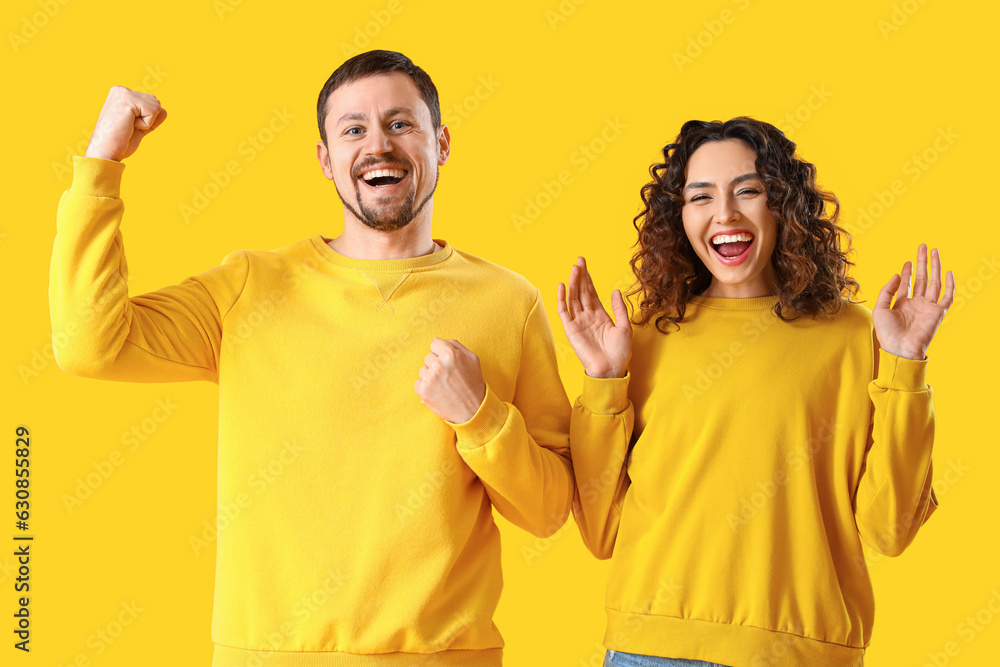 Happy young couple on yellow background