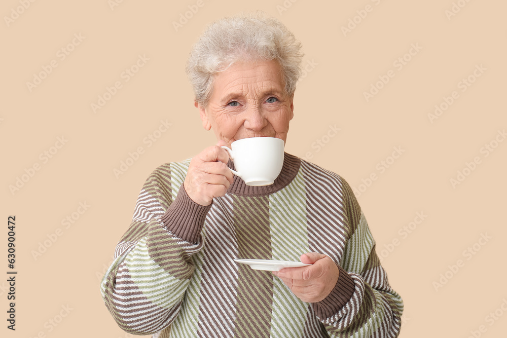 Senior woman drinking coffee on beige background