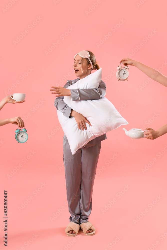 Young woman in pajamas and female hands with things on pink background