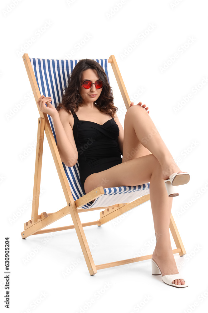 Young woman in deck chair on white background