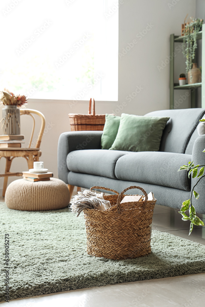 Interior of light living room with sofa and wicker basket