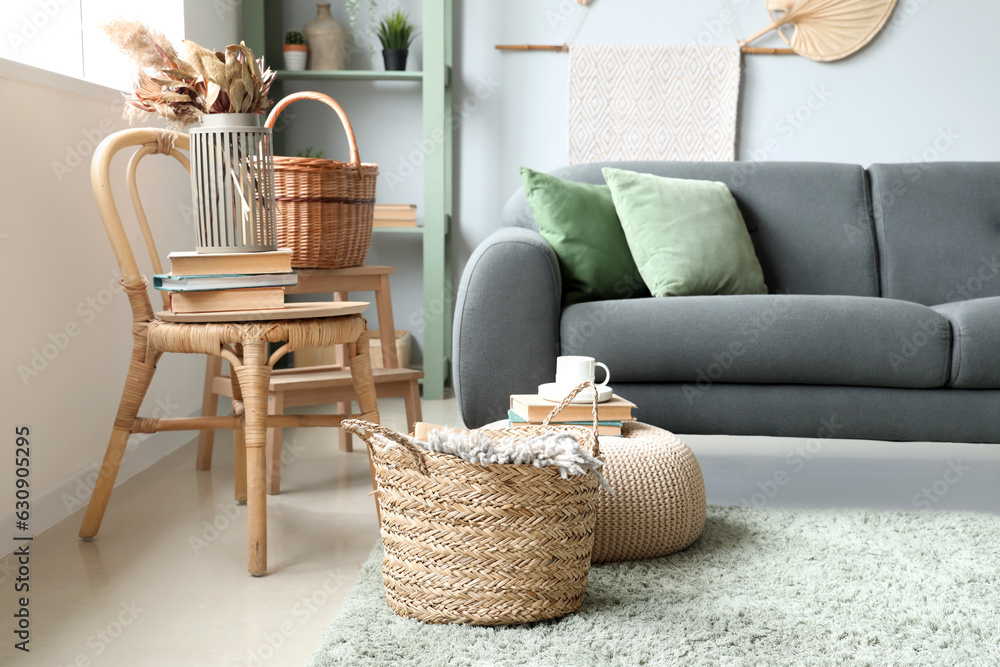 Interior of living room with sofa, wicker basket and chair