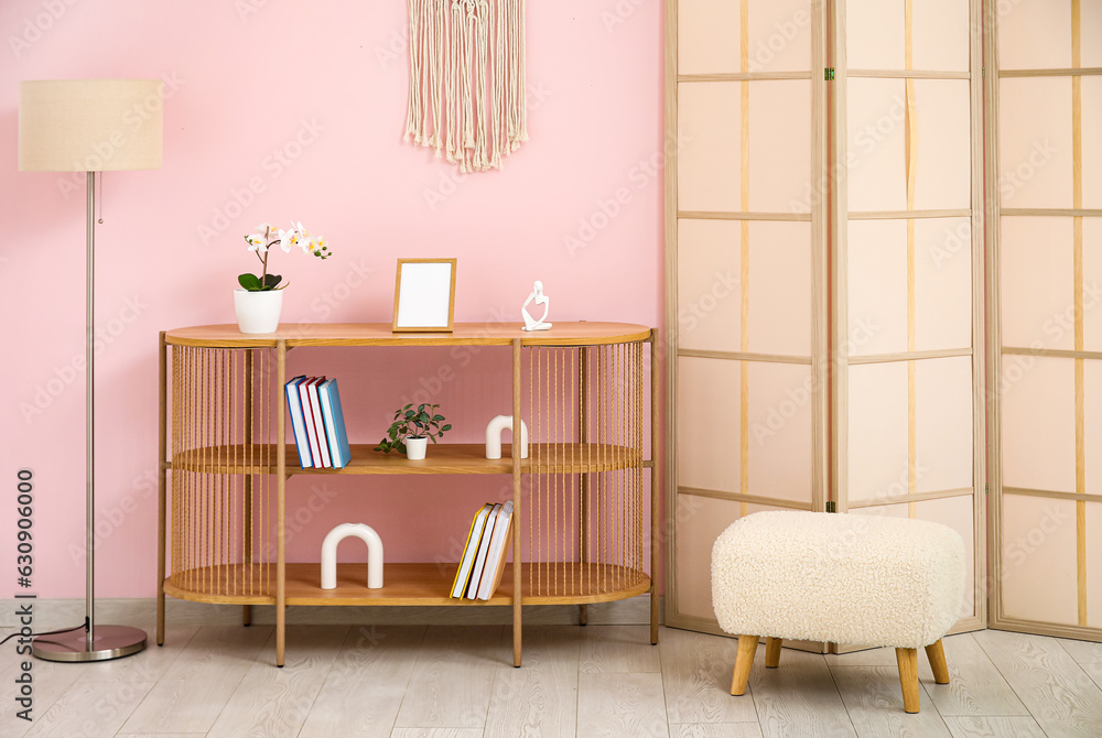 Bookshelf with flowers in interior of living room