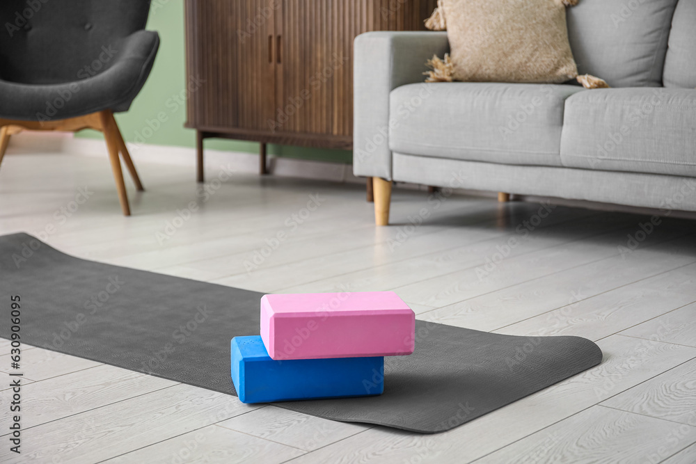 Blocks on yoga mat in living room, closeup