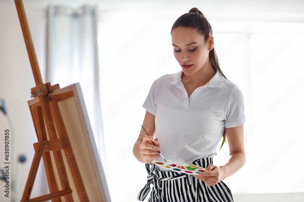 Young woman painting on her day off at home