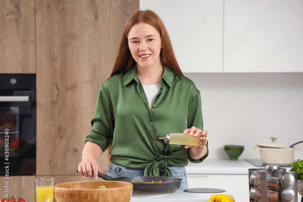 Young woman with oil frying vegetables in kitchen