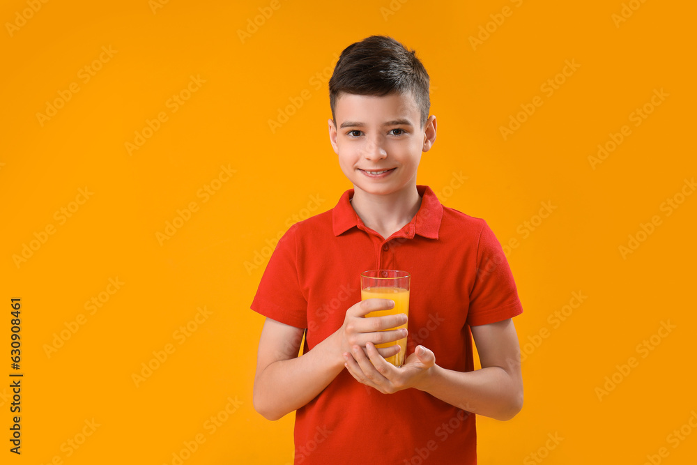 Little boy with glass of orange juice on color background