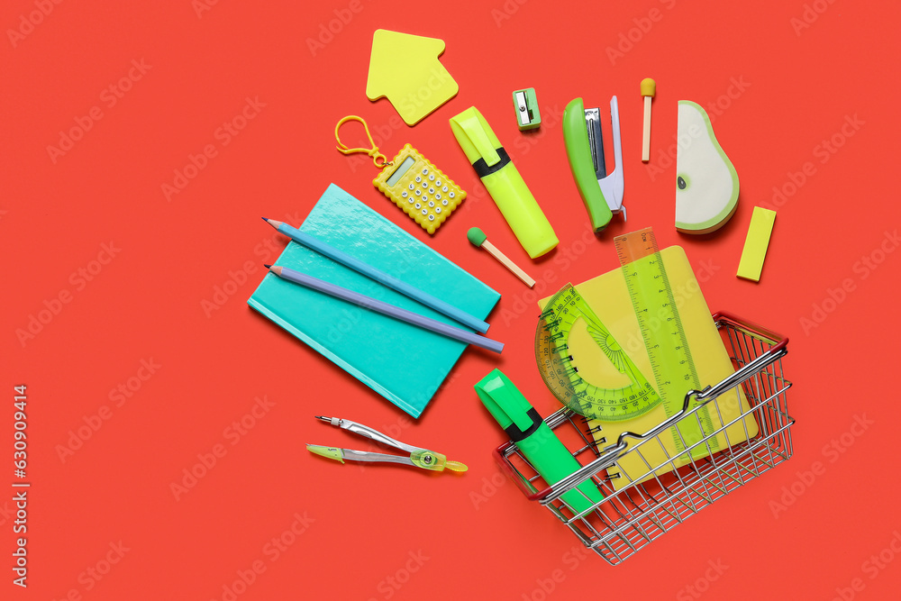 Composition with shopping basket and colorful stationery on color background