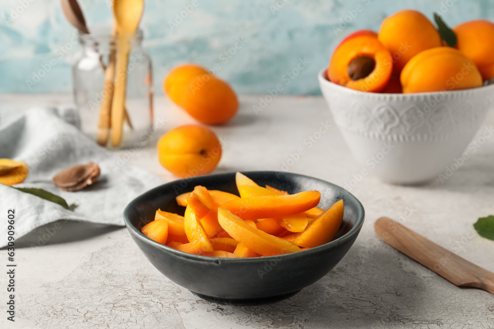 Bowl with pieces of sweet apricots on white table