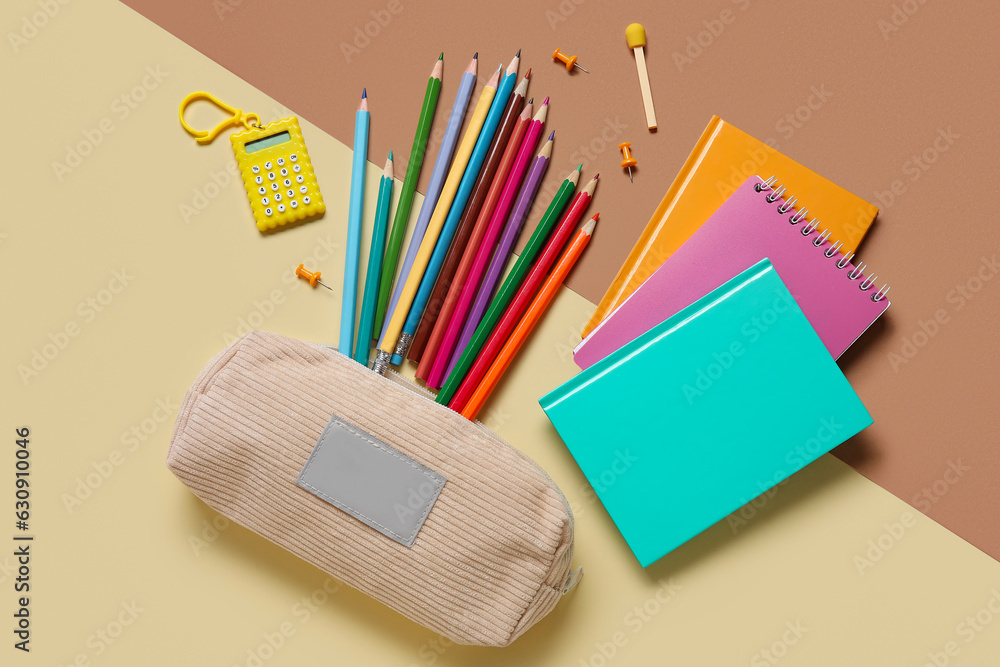 Pencil case with different school stationery on color background