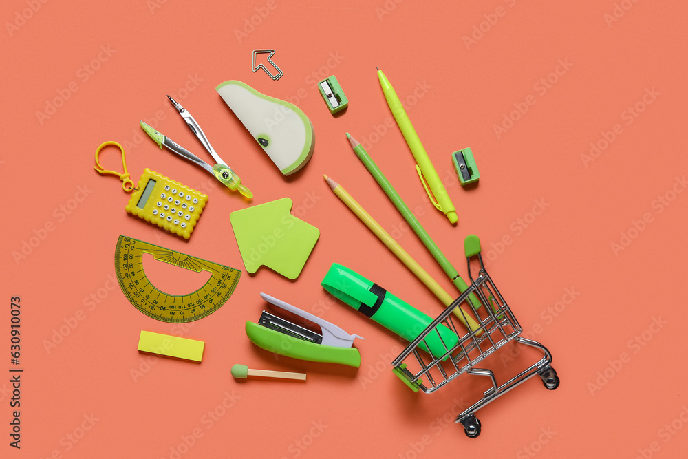 Shopping cart with different school stationery on orange background