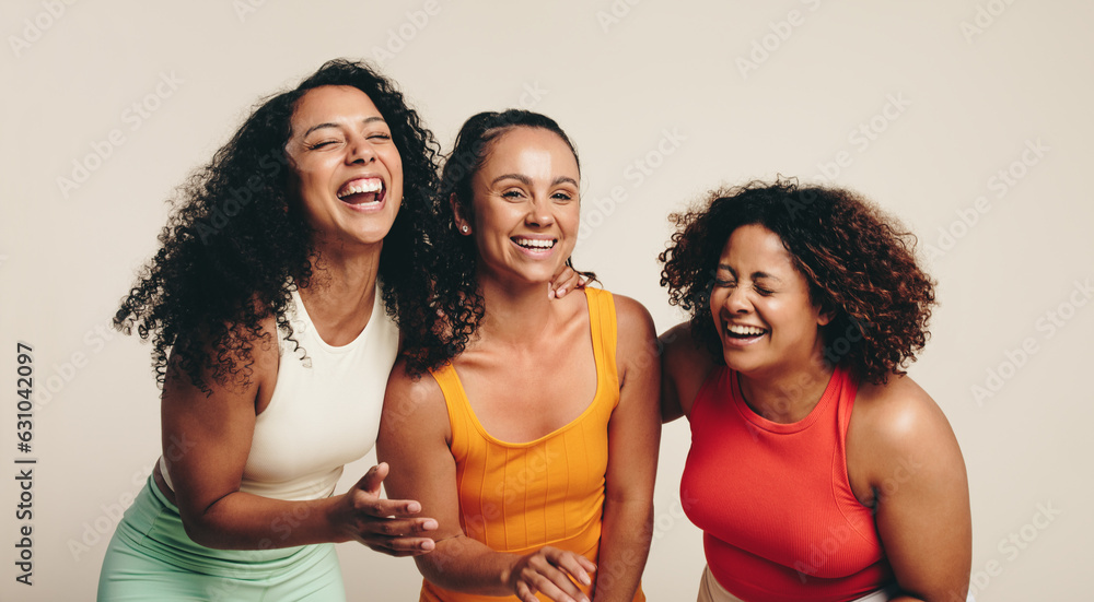 Sports, fitness and friendship: Group of young women laughing happily, dressed in sportswear