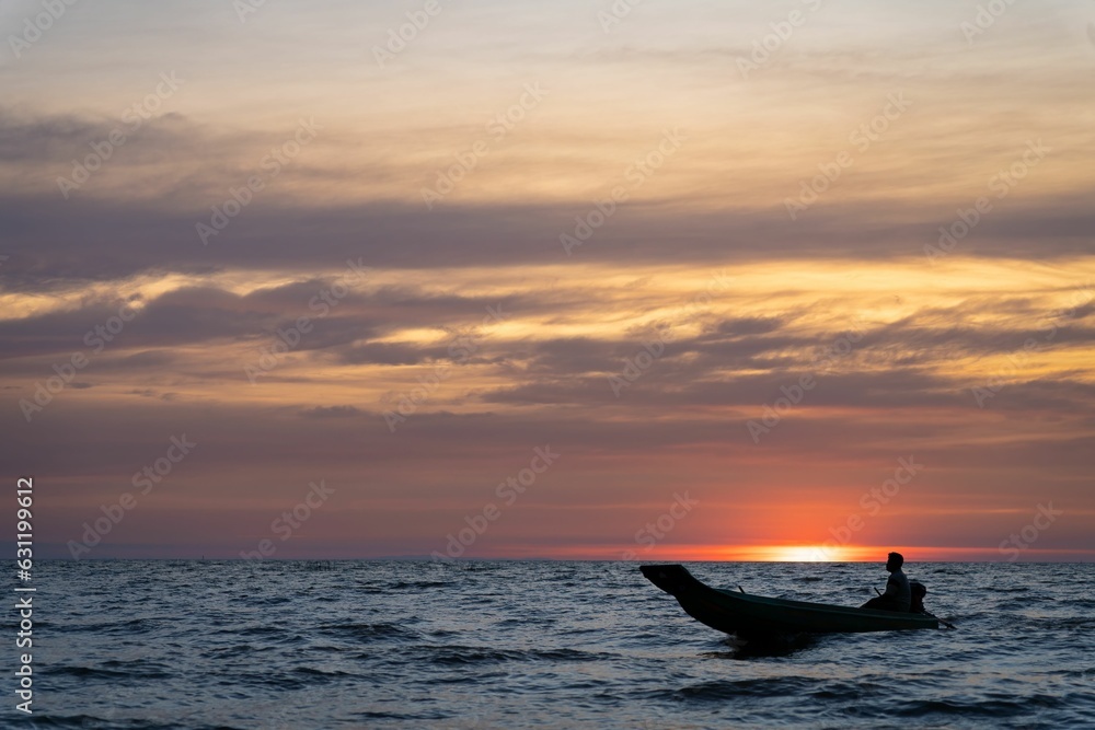 a silhouette of a person in the boat at Tonle Sap lake sunset, Cambodia