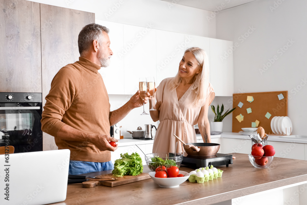 Mature couple drinking champagne in kitchen