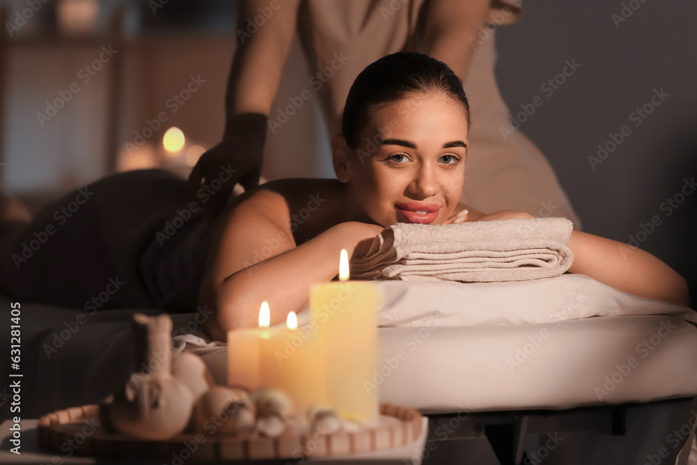 Pretty young woman having massage in spa salon