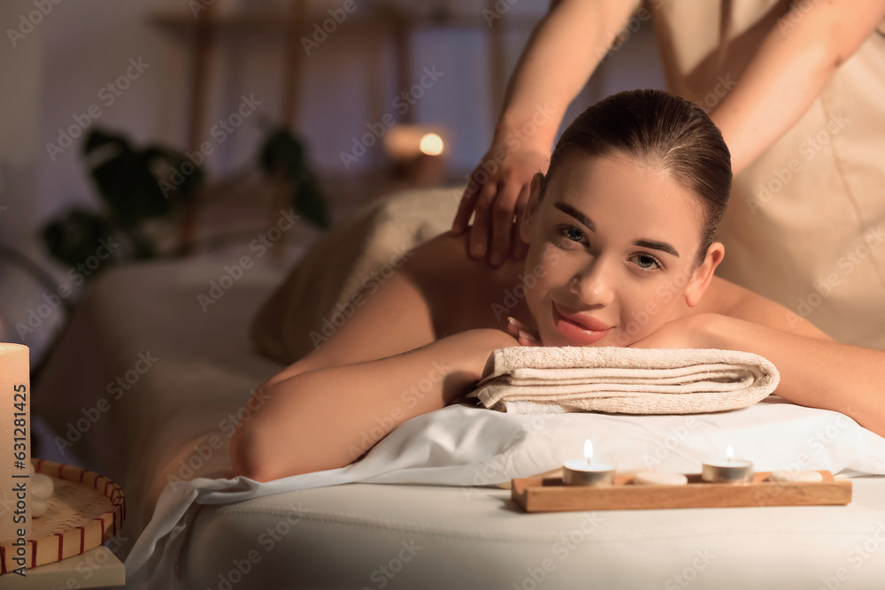 Pretty young woman having massage in spa salon