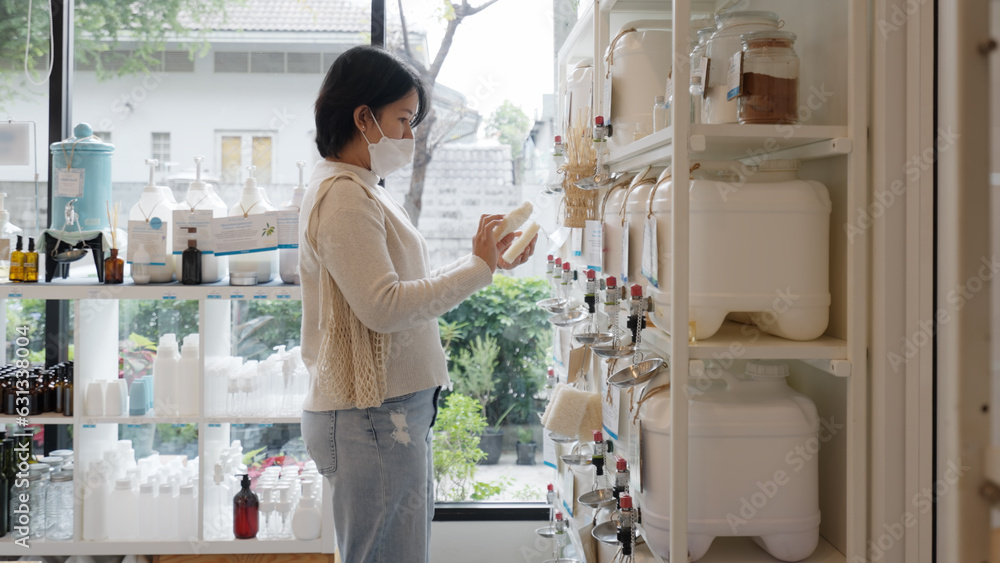 Asia vegan young adult woman carry bag happy buy eco bio goods glass jar pack on shelf. Trendy life 