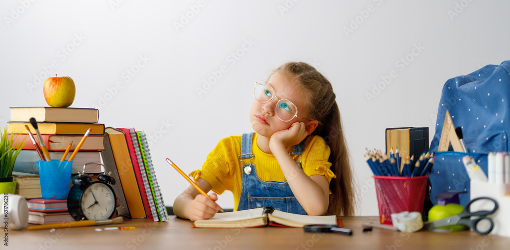 Thinking child is sitting at desk