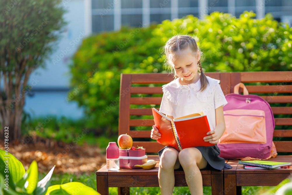 girl is having lunch sitting next to the school