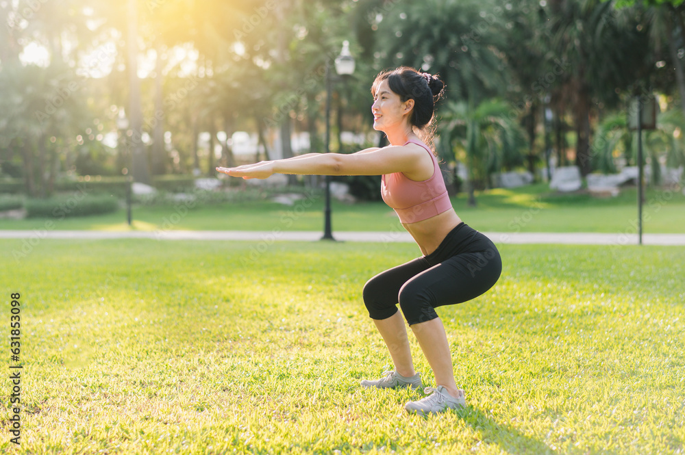 Healthy outdoor lifestyle with fit young Asian woman 30s wearing pink sportswear squat muscles in pu