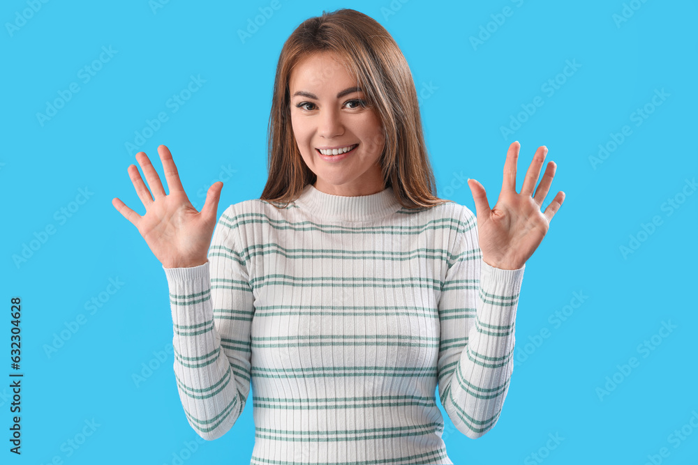 Beautiful woman showing hands on blue background