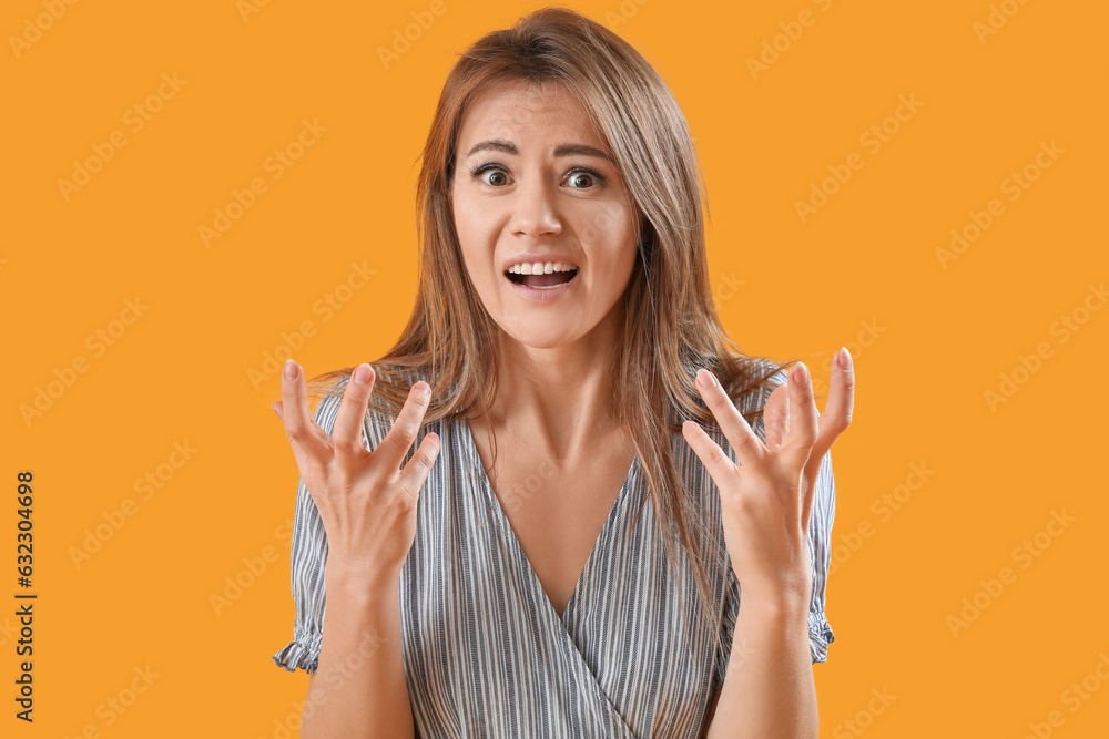 Stressed young woman in striped dress on yellow background, closeup