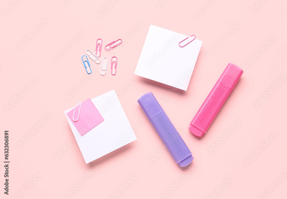 Sticky notes with paper clips and markers on pink background