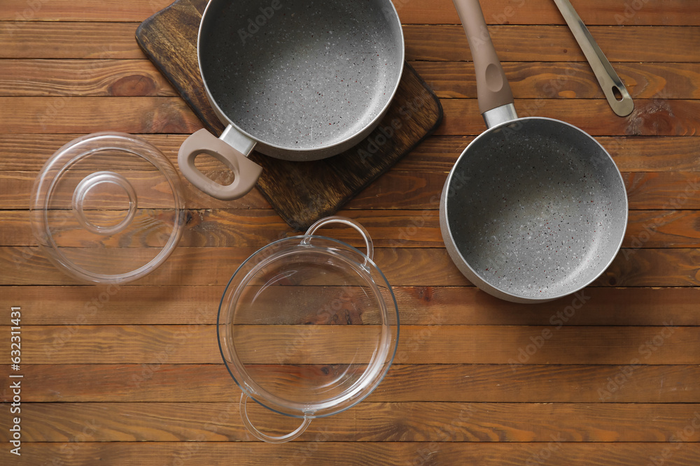 Set of cooking pots on wooden background